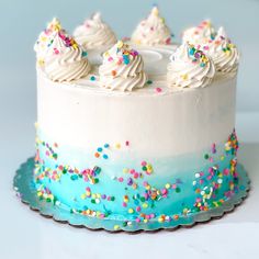 a cake with white frosting and colorful sprinkles