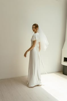 a woman in a white wedding dress is posing for the camera