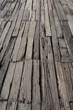 an old wooden walkway with no people walking on one side and the other side showing wood planks