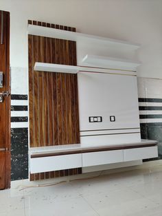 an empty room with a wooden wall and white furniture on the floor next to it