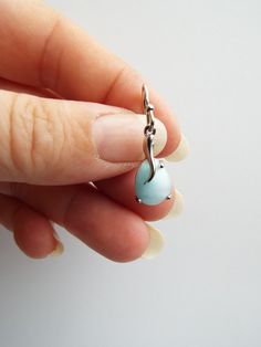 A pair of beautiful genuine Larimar and sterling silver earrings. This rare gemstone comes only from the Dominican Republic in the Caribbean, where it is sourced from the depths of the mountains of Barahona. It also goes by the name Dolphin Stone. Its beautiful blue and white hues are reminiscent of a tropical ocean or the sky on a summers day. Larimar is a stone of calm and relaxation and promotes peace and serenity to the wearer. Cabochon White Gold Earrings As Gift, White Gold Cabochon Earrings Gift, Turquoise Sterling Silver Earrings Fine Jewelry, Turquoise Sterling Silver Earrings - Fine Jewelry, Turquoise Sterling Silver Fine Jewelry Earrings, Larimar Cabochon Jewelry Gift, Aquamarine Earrings Gift, Silver Aquamarine Round Earrings, Larimar Dangle Earrings For Gifts