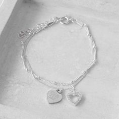 "Engraved Women's Personalized Heart Charm Sterling Silver Dainty Delicate Bracelet, Mom Gift --------------------------------------------------------------------------------------------------------------------- Delicate, classical, and feminine heart charm design. This gorgeous silver bracelet has got two 925 Sterling Silver heart pendants, on one of which you can engrave your personal message. GET CREATIVE and make it a ONE-OF-A-KIND with an engraving of your choice: initials, birthday, coordi Silver Chain Bracelet For Wedding Or Valentine's Day, Silver Chain Bracelet For Wedding, Silver Engraved Bracelets For Valentine's Day, Silver Double Heart Bracelets For Mother's Day, Engraved Silver Bracelets For Valentine's Day, Silver Engraved Bracelet Gift For Her, Silver Engraved Heart Bracelet For Valentine's Day, Silver Heart-shaped Chain Bracelet For Wedding, Engraved Silver Heart Bracelet For Wedding