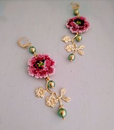 a pair of beaded earrings with flowers on them