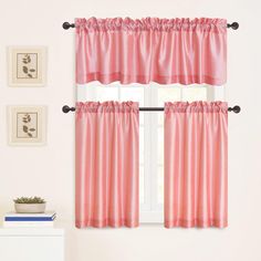 a window with pink curtains and pictures on the wall