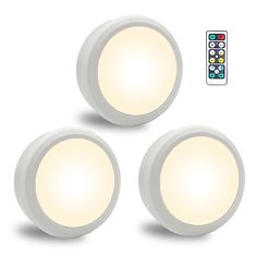 three white round lights with remote controls on the side and one light on the back