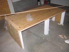 a wooden table with a plastic cup on it in the middle of a garage floor