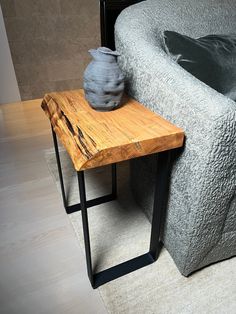 a wooden table sitting next to a gray couch