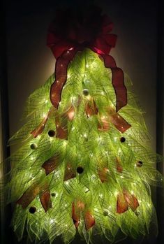 a green christmas tree with red bows and lights