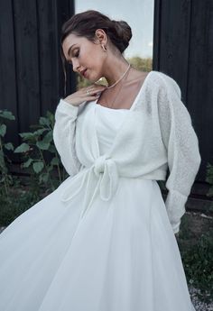 a woman in a white dress is posing for the camera