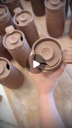 a hand holding a brown cup with many cups in it