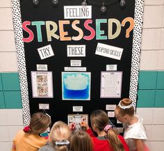 several children standing in front of a blackboard with words on it