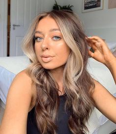 a woman with long hair sitting on a bed