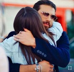 a man and woman hugging each other on the street