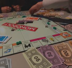 a monopoly board game is shown with money on the table and two people playing it