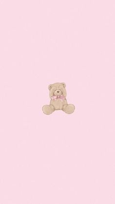 a brown teddy bear sitting on top of a pink wall