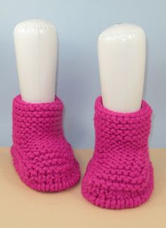 two white mannequins wearing pink knitted slippers