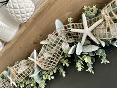 a close up of a wreath with starfishs and succulents on it