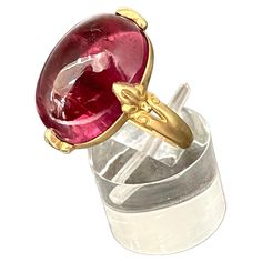 A clear 13 x 18 mm cabochon cut salmon pink tourmaline is held in 4 carved prongs in this Steven Battelle designed 18K gold setting. This allows for lots of light interplay and a lively stone. A tapered matte finish shank currently sized 7 completes. This ring is resizable. exquisite... Luxury Tourmaline Jewelry In Oval Cabochon Shape, Luxury Tourmaline Oval Cabochon Jewelry, Luxury Tourmaline Jewelry With Oval Cabochon, Elegant Round Ruby Intaglio Ring, Elegant Round Ruby Ring With Intaglio Detail, Elegant Oval Ruby Ring With Intaglio, Oval Tourmaline Jewelry For Formal Occasions, Formal Oval Tourmaline Jewelry, Pink Spinel