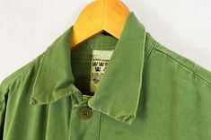 "True vintage Swedish military smock tops from the 1960s-80s, made from a soft cotton with grandad style button down neckline, button cuffs and curved hem. We only have a very small batch of these with no chance of re stock right now, so quantities are limited. - Soft worn in cotton - Loose, comfy fit - Dip hem design - True vintage from the Swedish army - Fabric is 100% cotton SIZING XS - fits chest 34\" Small - fits chest 36\", Medium - fits chest 38\"-40\", Large - fits chest 42\"-44\" XL - f Khaki Cotton Tops With Buttons, Utility Cotton Tops With Buttons, Cotton Utility Tops With Buttons, Military Style Cotton Tops With Snap Buttons, Khaki Cotton Tops With Snap Buttons, Vintage Button-up Outerwear For Daywear, Military Style Collared Cotton Top, Vintage Khaki Tops With Snap Buttons, Green Cotton Outerwear For Daywear