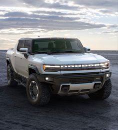 a white truck parked on top of a sandy beach