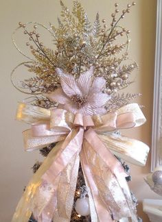 a christmas tree decorated with pink and gold ribbons