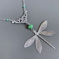 "Large Silver Dragonfly Necklace -  Large Antiqued Silver plated Dragonfly dangles from a Turquoise Czech Glass  Bead and Antiqued Silver Floral Connector with 2 small Czech Turquoise Glass Beads. The dragonfly is 2\" high x 2.5\" wide (63mm x 50mm) and has a hollow back. Chain Length is approximately 28.5\".  The Dragonfly hangs down an additional 4\" from the chain. Stainless Steel Chain For other dragonfly jewelry:  https://www.etsy.com/shop/mcstoneworks/search?search_query=dragonfly&order=da Elegant Green Dragonfly Shaped Jewelry, Green Dragonfly Jewelry For Gifts, Green Dragonfly Jewelry As A Gift, Green Dragonfly Jewelry Gift, Green Adjustable Jewelry With Butterfly Charm, Green Bohemian Butterfly Jewelry, Bohemian Green Butterfly Jewelry, Handmade Green Dragonfly Jewelry, Bohemian Silver Dragonfly Necklace