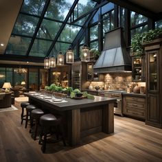 a large kitchen with lots of counter space and lights hanging from the ceiling above it