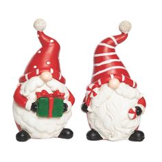 two ceramic santa claus figurines with presents on their feet, both wearing red and white hats