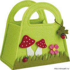 a green felt purse with mushrooms and ladybugs on the front, sitting in grass