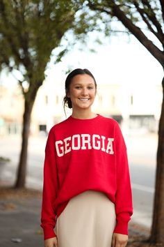 Our Georgia Sweater is such an adorable top! It is made of the softest fibers and has a slight oversized fit. This is perfect for those cooler autumn/winter days! - Crew neck - Long sleeves - Soft fibers - Slight oversized fit - Material: 52% Viscose | 28% Polyester | 20% Nylon - Model is 5’6" & wears a small. She is wearing a small in this sweater. Color Disclaimer: Actual colors may vary due to computer monitors. *Measurements are taken flat and then doubled.* Size Bust Length Sleeve Small 47" Oversized Red Sweater With Letter Print, Red Letter Print Sweater For Fall, Trendy Fall Sweatshirt For Campus, Trendy Sweatshirt For Campus In Fall, Trendy Campus Sweatshirt For Fall, Oversized Fall Tops For College, Oversized Tops For College In Fall, Oversized Collegiate Winter Sweatshirt, Oversized Red Sweatshirt With Ribbed Cuffs