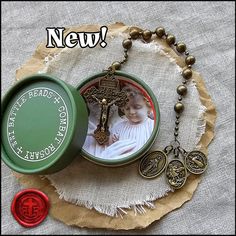 a small green box with a cross and two medallions on it next to a red wax seal