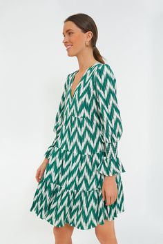 A Tuckernuck fan favorite, the Green Ikat Kenzo Dress is the mini of the season. Featuring feminine flutter smocked cuffs, a V-neckline and a loose empire waist, this is the most flattering flirty frock! Pair with flats for a casual look or dress it up with heels and statement earrings for date night. V-neckline Long sleeves Elasticated ruffle cuff Swing shape Tiered skirt Mini length Material: 75% Rayon, 25% Nylon Care: Hand wash cold Green V-neck Midi Dress With Smocked Bodice, Chic V-neck Smocked Dress With Ruffle Hem, V-neck Smock Mini Dress For Brunch, V-neck Smocked Mini Dress For Brunch, V-neck Smocked Dress With Ruffle Hem For Brunch, V-neck Smocked Dress For Brunch With Smocked Cuffs, Chic Green Dress With Smocked Cuffs, Vacation Smocked V-neck Dress With Smocked Cuffs, Vacation V-neck Smocked Dress With Smocked Cuffs