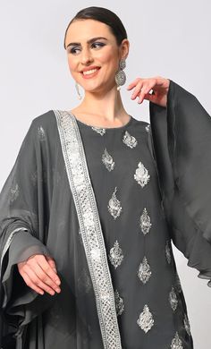 Step into the spotlight with our breathtaking 3-piece Garara Set, meticulously crafted to elevate your style to new heights. Adorned with intricate silver zari and foil work embroidery, the kurti exudes an aura of timeless elegance, while the heavy foil border on the kurta and garara hem adds a touch of opulence. Each motif tells a story of exquisite craftsmanship, shimmering gracefully with every movement. The ensemble is completed with a dupatta featuring a matching foil border, tying the look Semi-stitched Silver Anarkali Set For Festivals, Elegant Georgette Sets With Mirror Work, Formal Palazzo Set With Dabka, Semi-stitched Silver Sets For Eid, Silver Dupatta With Mirror Work For Party, Party Wear Silver Dupatta With Mirror Work, Silver Mirror Work Dupatta For Party, Silver Party Wear Sets For Festive Occasion, Festive Silver Party Wear Sets