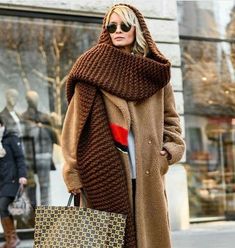 a woman is walking down the street carrying shopping bags