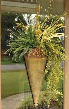 a vase filled with flowers sitting on top of a window sill next to a planter