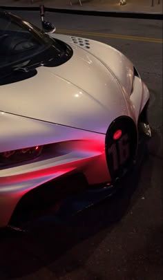 a white sports car is parked on the street