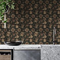 a kitchen with a sink, counter top and wall paper in the backround