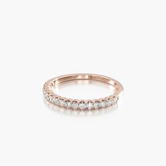 a rose gold ring with five diamonds on the side, set against a white background