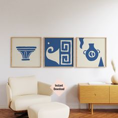 three blue and white paintings hang on the wall above a chair in a living room