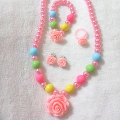 a necklace and earring set made out of plastic beads with pink roses on them