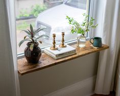 a window sill with plants and books on it