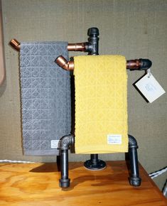 two towels sitting on top of a wooden table in front of a wall mounted heater