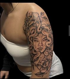 a woman's arm with an intricate tattoo design on her left arm and shoulder