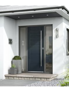 the front door to a modern home with potted plants