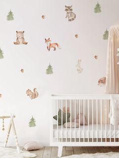 a baby's room with white walls and woodland animals on the wall