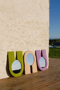 three different shaped mirrors sitting on top of a wooden floor