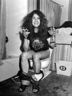 a black and white photo of a woman sitting on a toilet