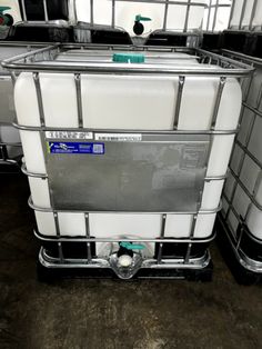 a large white container sitting on top of a wooden floor next to metal bars and shelves