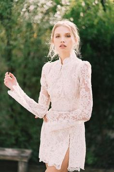 a woman in a white dress is posing for a photo with her hands on her hips