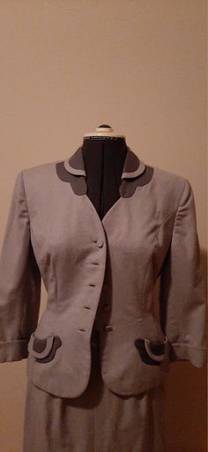 This is a beautiful wool suit from Wells of Evenvilles, there are covered buttons and side pockets.  The jacket is fitted and there is a matching pencil skirt.  The skirt has zippers on both the right and left side.  This is a well made two piece suit the jacket is fully lined.  The pockets have a extra little decoration around them.  This suit will fit size 5 to 6 easily, the skirt waistline is 24 , the hip area is about 36 and the skirt from waistline to hemline is about 30 inches. I do not ac Elegant Formal Wool Skirt Suit, Elegant Wool Skirt Suit For Formal Occasions, Formal Fitted Single Button Skirt Suit, Fitted Single Button Skirt Suit For Formal, Fitted Single Button Skirt Suit For Formal Occasions, Classic Long Sleeve Skirt Suit For Tailoring, Fitted Skirt Suit With Button Closure For Work, Tailored Career Skirt Suit With Buttons, Classic Tailored Skirt Suit With Suit Collar